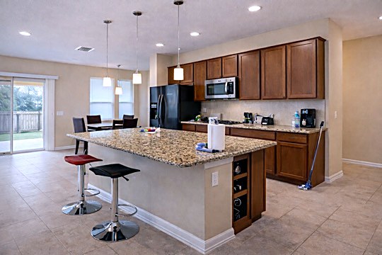 Fully equipped shared kitchen with granite island and stainless appliances in Austin room rental