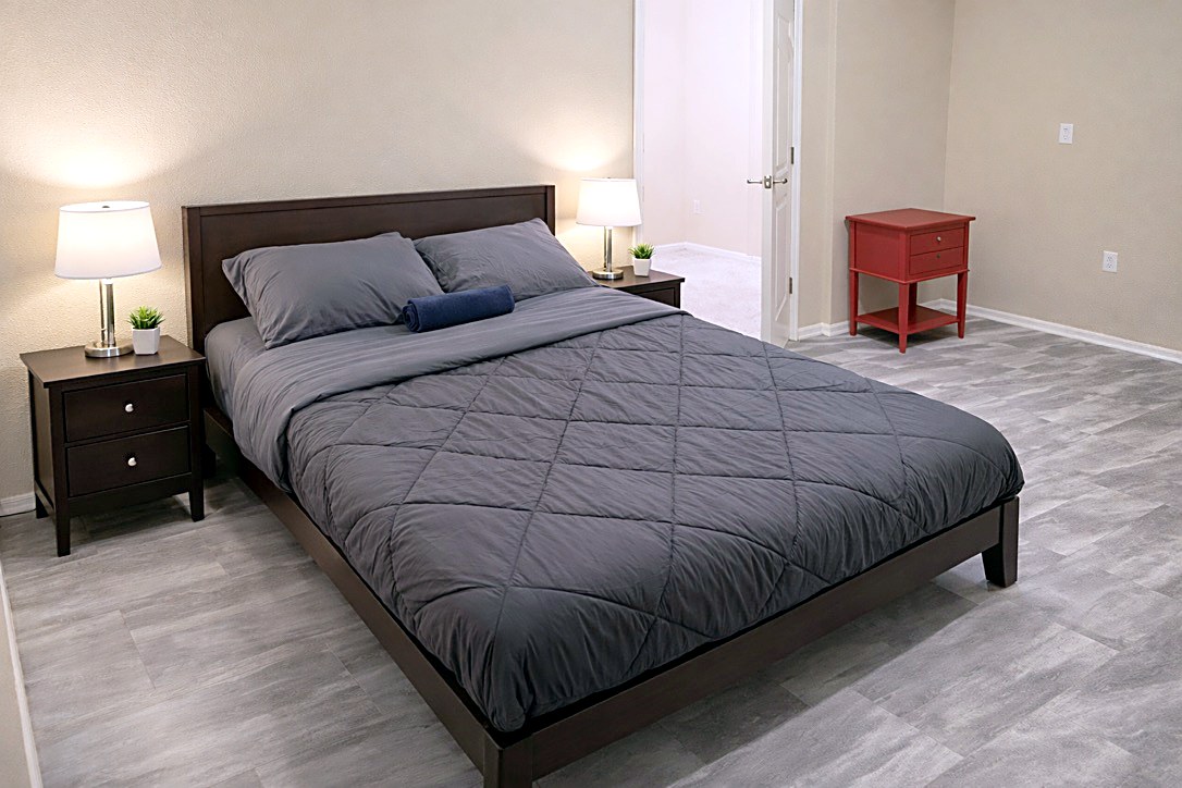Room 1 furnished first-floor bedroom with queen bed, two nightstands and desk in North Austin