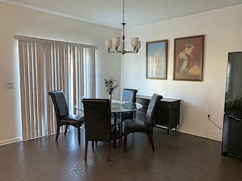 Dining area with glass table and chandelier in furnished corporate house near Pioneer Crossing Austin